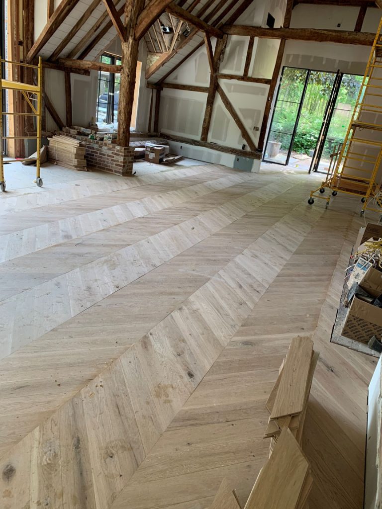 select white oak chevron floor installation in Watermill