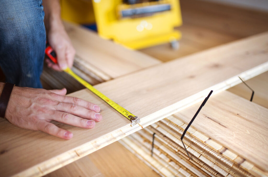 handyman measuring hardwood floor