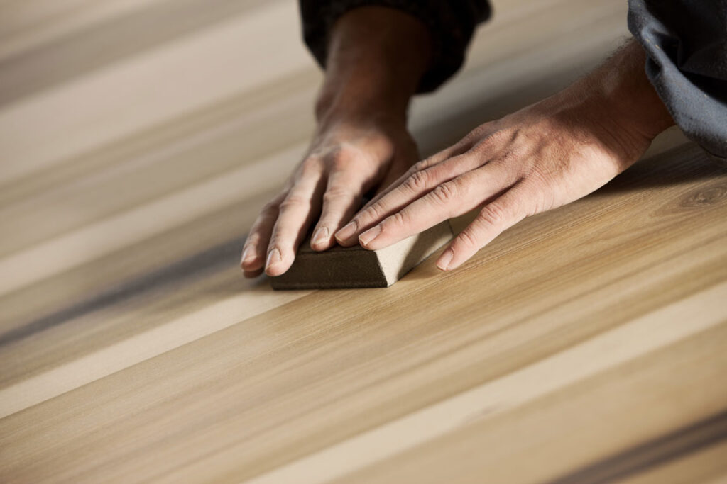 man refinishing hardwood flooring