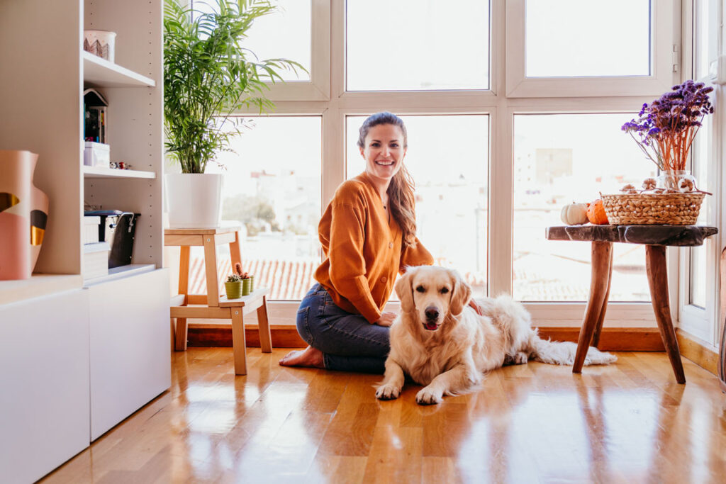 woman at home on her wood flooring with her golden retriever