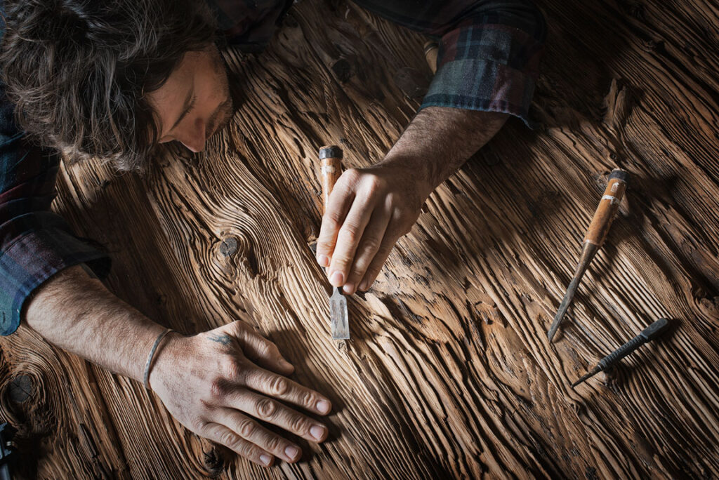 man working on reclaimed wood with tools