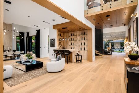 Modern open-concept living area with wooden floors and bar. home showing open floor plan with wood floors