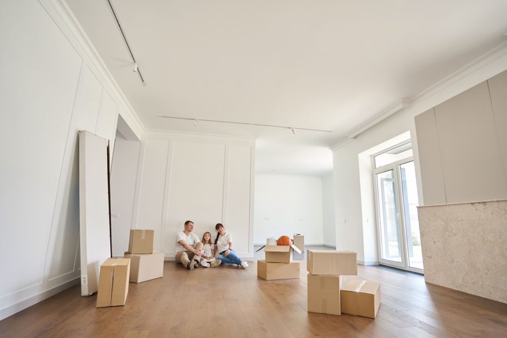 european-family-sitting-on-floor-and-looking family sitting on engineered wood flooring