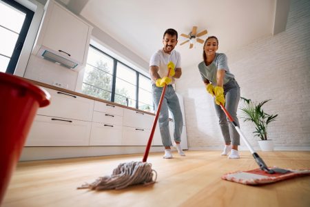Man and woman cleaning a wood floor together